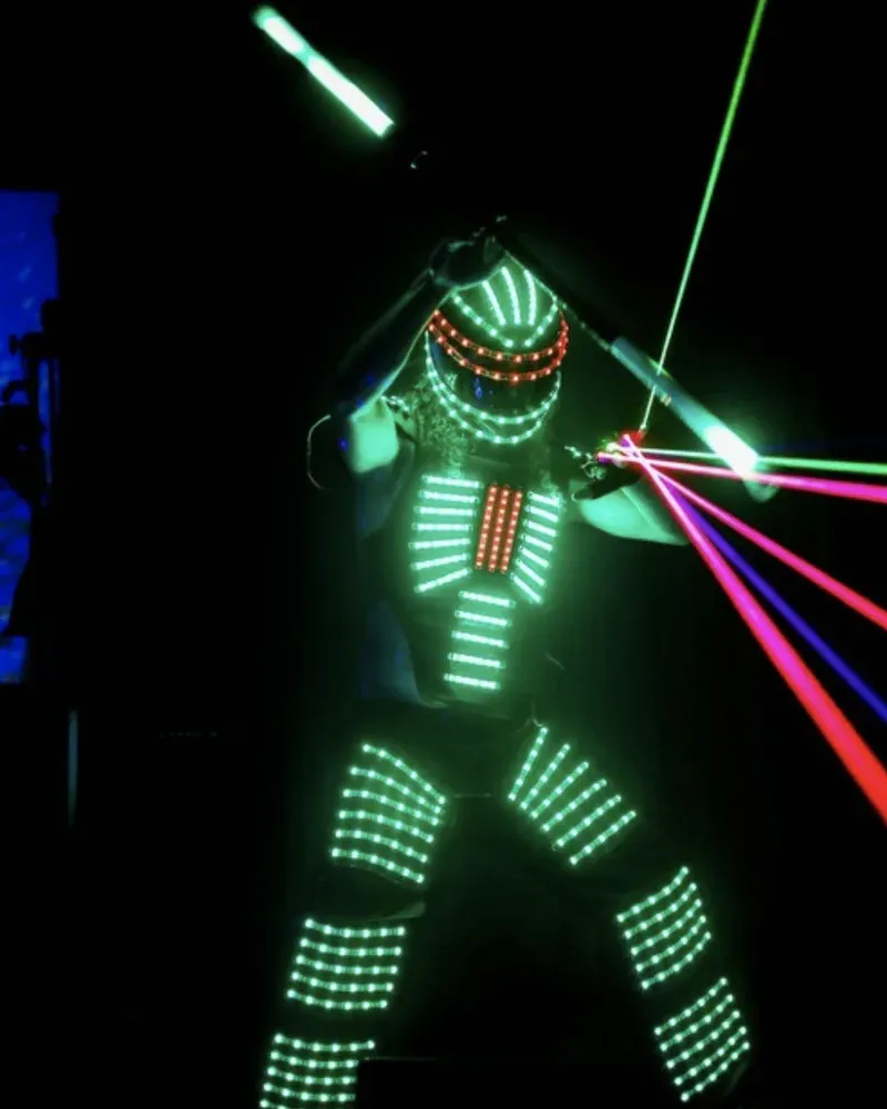 Performer in a programmable LED robot costume firing handheld lasers