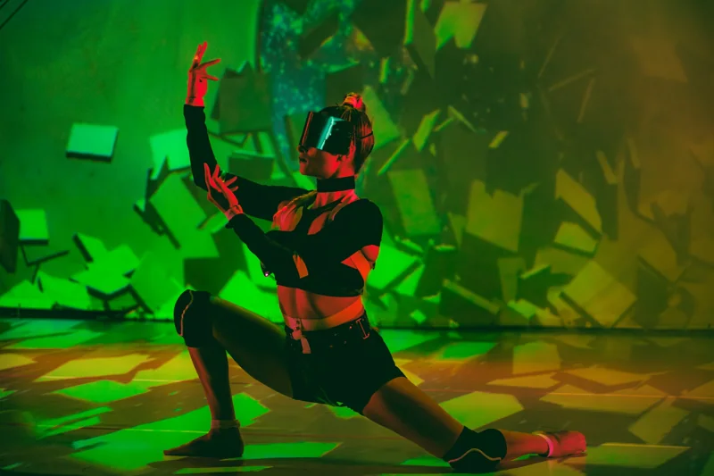 Reality Collapse performer in a helmet under green projection